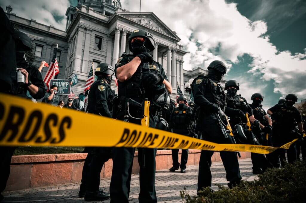 Police standing in front of city hall behind barricade tape